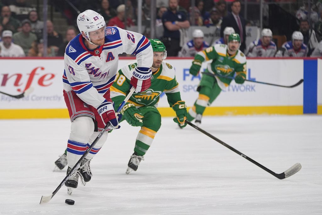 New York Rangers defenseman Adam Fox (23) skates with the puck during the first period of an NHL hockey game against the Minnesota Wild, Saturday, March 14, 2026, in St. Paul, Minn. (AP Photo/Abbie Parr)