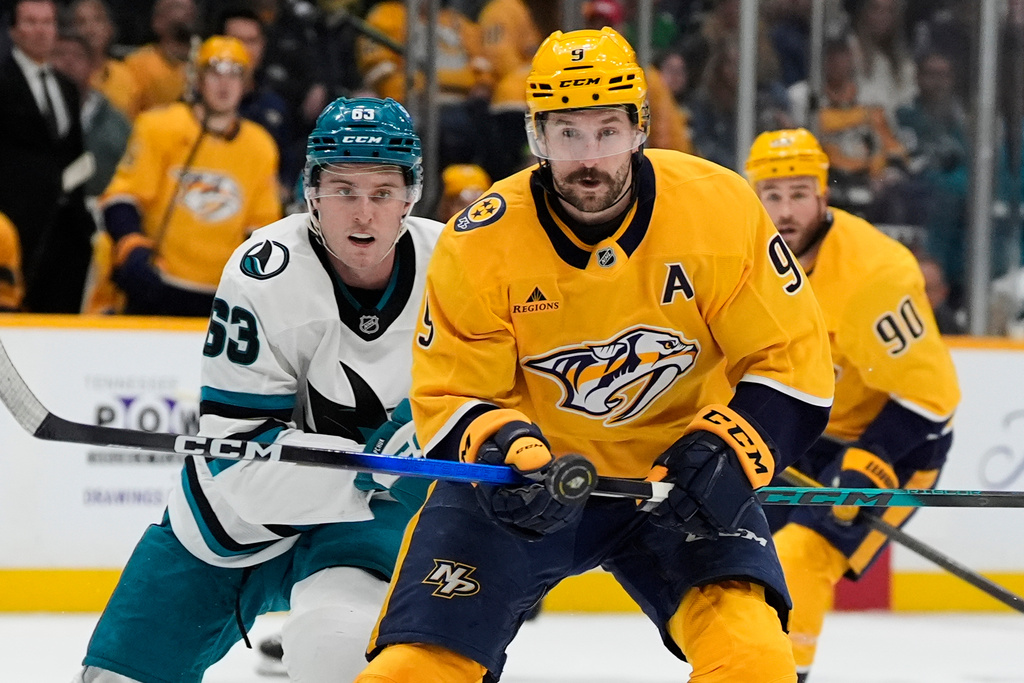 Nashville Predators left wing Filip Forsberg (9) chases the puck past San Jose Sharks center Zack Ostapchuk (63) during the second period of an NHL hockey game Tuesday, March 24, 2026, in Nashville, Tenn. (AP Photo/George Walker IV)