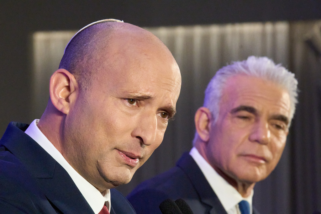 Former Israeli prime ministers Naftali Bennett, left, and Yair Lapid hold a joint press conference announcing that their parties will run together in the upcoming elections, in Herzliya, Israel, Sunday, April 26, 2026. (AP Photo/Ariel Schalit)