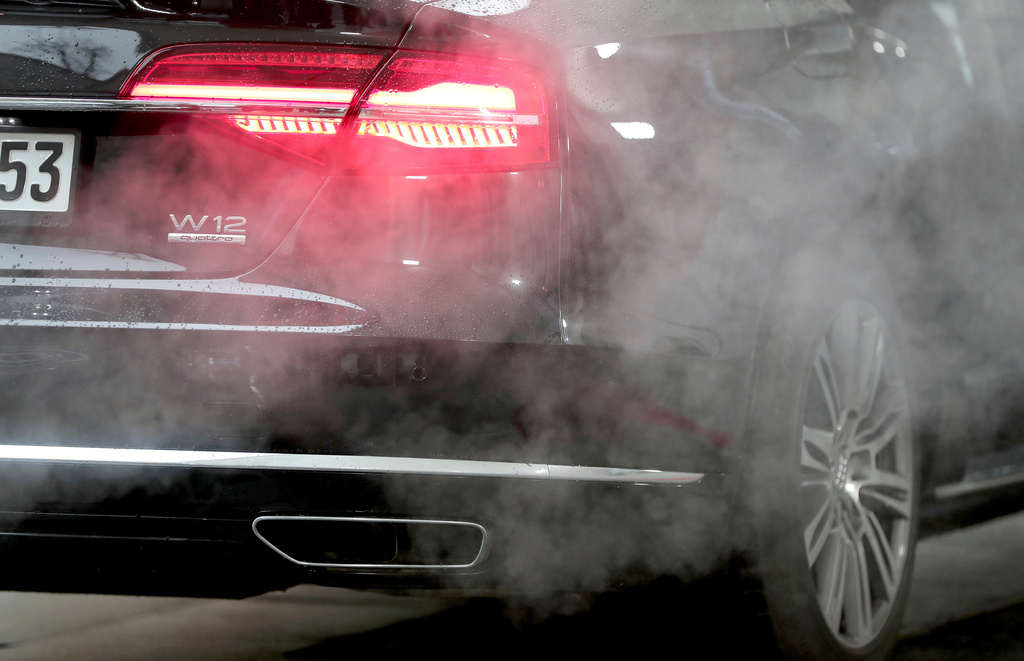FILE - A luxury Audi car is surrounded by exhaust gases as it is parked with a running engine in front of the Chancellery in Berlin, Germany, Wednesday, Nov. 20, 2019. (AP Photo/Michael Sohn, File)