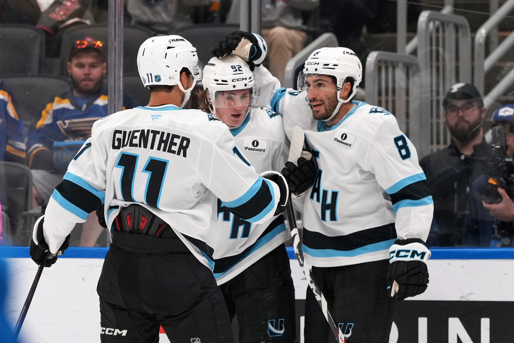 Utah Mammoth's Nick Schmaltz (8) is congratulated by teammates Logan Cooley and Dylan Guenther (11) after scoring during the third period of an NHL hockey game against the St. Louis Blues Thursday, Oct. 23, 2025, in St. Louis. (AP Photo/Jeff Roberson)