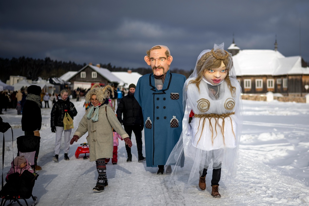 Performers dressed as newlyweds take part in Shrovetide celebrations in the village of Rumsiskes, some 89 kilometers (56 miles) north of Vilnius, Lithuania, Saturday, Feb. 14, 2026. (AP Photo/Mindaugas Kulbis)