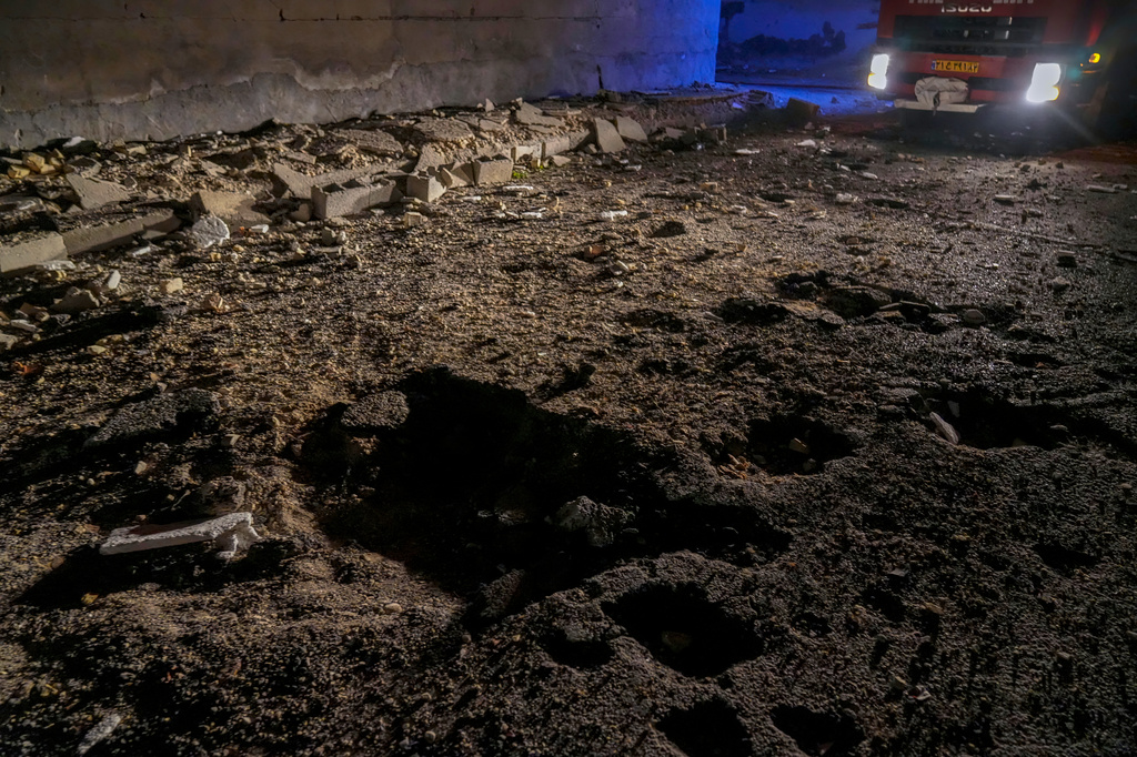 A fire truck's lights reveal a road damaged by a strike in Lamerd, southern Iran, Saturday, Feb. 28, 2026.(Alireza Ameri/Tasnim News Agency via AP)