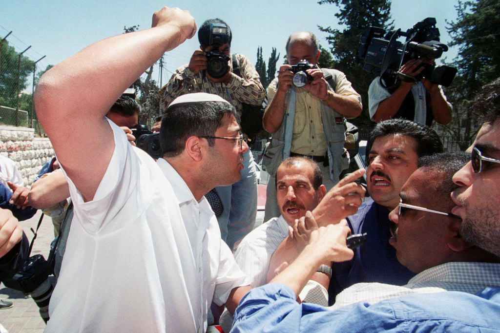 FILE - Itamar Ben-Gvir, an extreme right-wing Israeli activist, raises his fist at Palestinian guards as a few dozen Israelis marched through traditionally Arab east Jerusalem on Jerusalem Day, June 1, 2000. (AP Photo/Jacqueline Larma, File)