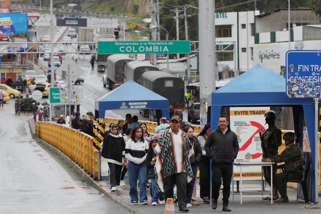 Pedestrians cross the Rumichaca international bridge from Colombia to Ecuador in Rumichaca, Colombia, Thursday, Jan. 22, 2026. (AP Photo/Leonardo Castro)
