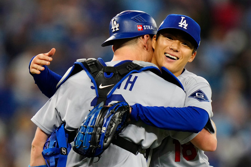 Los Angeles Dodgers catcher Will Smith (16) congratulates pitcher Yoshinobu Yamamoto (18) after he pitched a complete game, defeating the Toronto Blue Jays in Game 2 of baseball's World Series, Saturday, Oct. 25, 2025, in Toronto. (Frank Gunn/The Canadian Press via AP) Los Angeles Dodgers catcher Will Smith (16) congratulates pitcher Yoshinobu Yamamoto (18) after he pitched a complete game, defeating the Toronto Blue Jays in Game 2 of baseball's World Series, Saturday, Oct. 25, 2025, in Toronto. (Frank Gunn/The Canadian Press via AP)