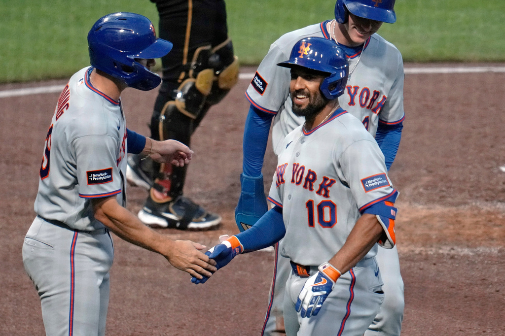 New York Mets' Marcus Semien (10) celebrates with Jared Young, left, and Carson Benge, back right, after hitting a three-run home run off Pittsburgh Pirates pitcher Carmen Mlodzinski during the third inning of a baseball game in Pittsburgh, Friday, Aug. 7, 2026. (AP Photo/Gene J. Puskar)