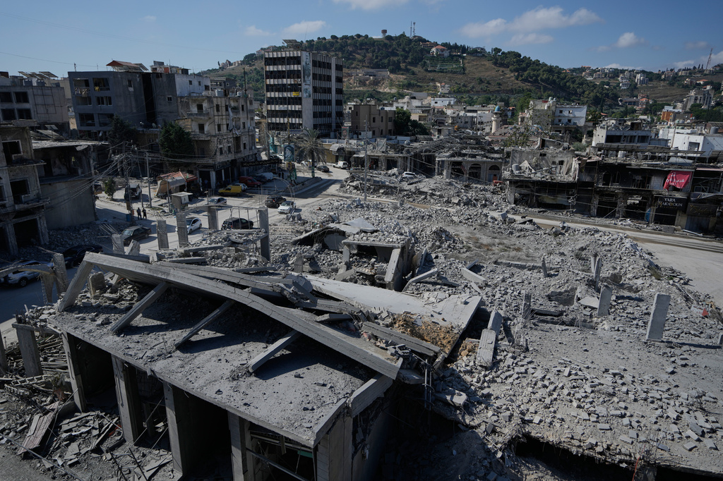 FILE - People drive past buildings destroyed in Israeli airstrikes in the town of Nabatiyeh, southern Lebanon, June 24, 2026. (AP Photo/Bilal Hussein, File)