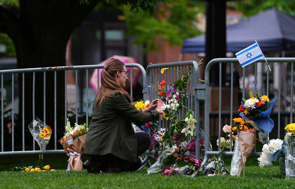 FILE - A woman places a bouquet of flowers at a makeshift memorial for victims of an attack outside of the Boulder County, Colo., courthouse Tuesday, June 3, 2025, in Boulder, Colo. (AP Photo/David Zalubowski, File)