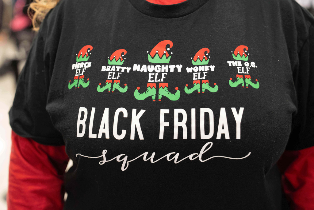 The shirt of a woman who has matching shirts with 4 other friends and all shop together on Black Friday as shoppers browse through Kohl's department store for Black Friday looking for deals, Friday, Nov. 28, 2025, in Woodstock, Ga. (AP Photo/Megan Varner)