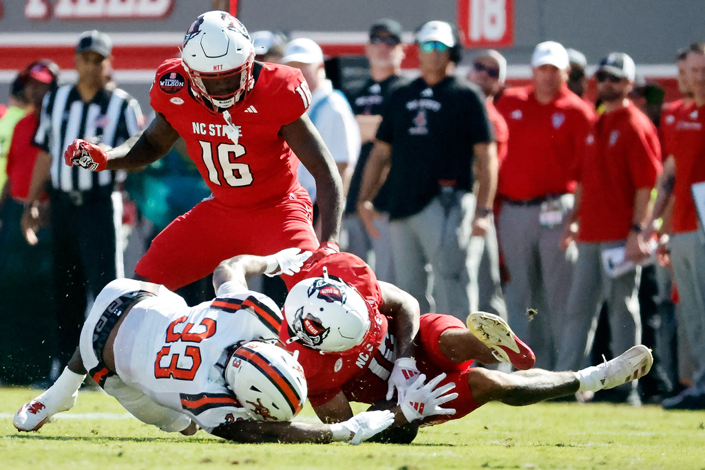 North Carolina State's Teddy Hoffmann (12) tries to secure the ball from Campbell's Tyrek Brown (33) after muffing the punt with Tank Boston (16) during the first half of an NCAA college football game in Raleigh, N.C., Saturday, Oct. 4, 2025. (AP Photo/Karl DeBlaker)
