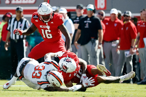 North Carolina State's Teddy Hoffmann (12) tries to secure the ball from Campbell's Tyrek Brown (33) after muffing the punt with Tank Boston (16) during the first half of an NCAA college football game in Raleigh, N.C., Saturday, Oct. 4, 2025. (AP Photo/Karl DeBlaker) North Carolina State's Teddy Hoffmann (12) tries to secure the ball from Campbell's Tyrek Brown (33) after muffing the punt with Tank Boston (16) during the first half of an NCAA college football game in Raleigh, N.C., Saturday, Oct. 4, 2025. (AP Photo/Karl DeBlaker)
