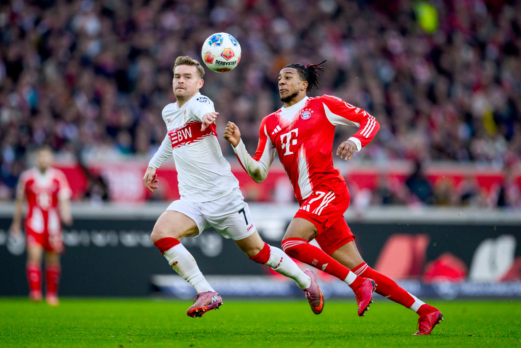 Munich's Michael Olise, right, and Stuttgart's Maximilian Mittelstaedt, left, challenge for the ball during the German Bundesliga soccer match between VfB Stuttgart and FC Bayern Munich in Stuttgart, Germany, Saturday, Dec. 6, 2025. (Tom Weller/dpa via AP)