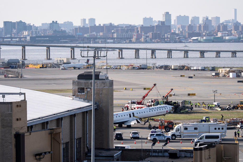 An airport maintenance crew moves the wreckage of an Air Canada Express jet, Wednesday, March 25, 2026, from the runway where it had collided with a Port Authority fire truck Sunday night at LaGuardia Airport, in New York. (AP Photo/Yuki Iwamura)