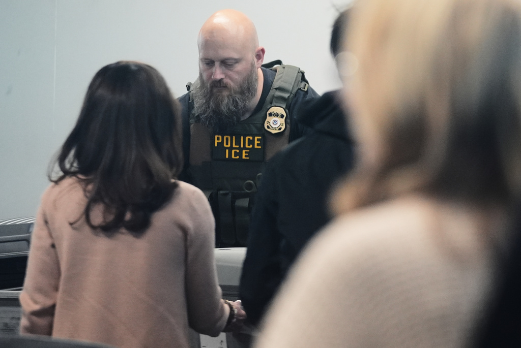 An Immigration and Customs Enforcement (ICE) agent works at the baggage check at O'Hare International Airport in Chicago, Tuesday, March 24, 2026. (AP Photo/Nam Y. Huh)