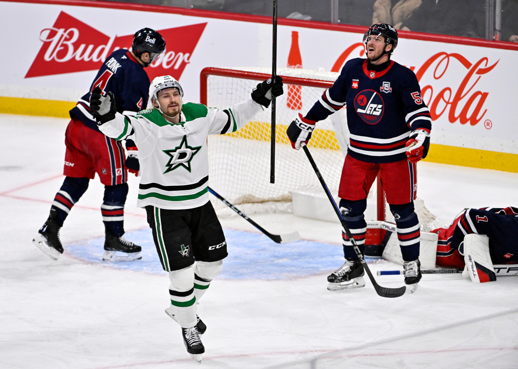Dallas Stars' Roope Hintz (24) celebrates a goal by teammate Jason Robertson against the Winnipeg Jets during the third period of their NHL hockey game in Winnipeg, Tuesday, Dec. 9, 2025. (Fred Greenslade/The Canadian Press via AP)