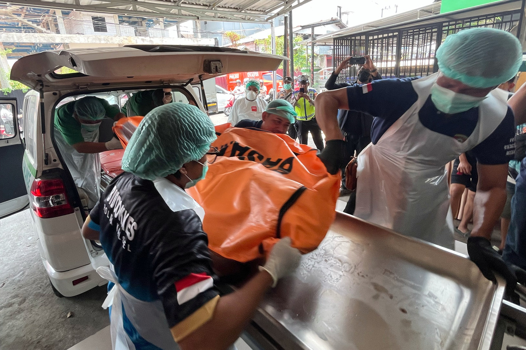 In this photo taken with a smartphone, staff remove the body of a victim of a passenger ferry that overturned in bad weather in the Java Sea from an ambulance upon arrival at a hospital in Banjarmasin, South Kalimantan, Indonesia, Tuesday, Sept. 15, 2026. (AP Photo/Iman Satria)