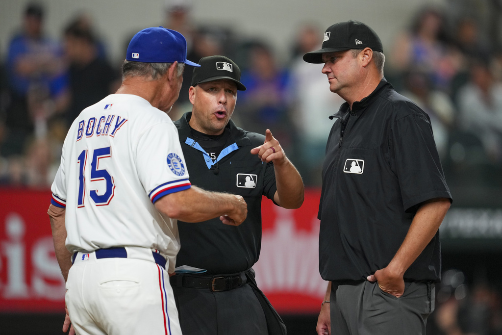 Texas Rangers manager Bruce Bochy (15) argues with home plate umpire Stu Scheurwater, left, and third base umpire John Bacon after being ejected from a baseball game during the eighth inning Saturday, Sept. 20, 2025, in Arlington, Texas. (AP Photo/Julio Cortez)