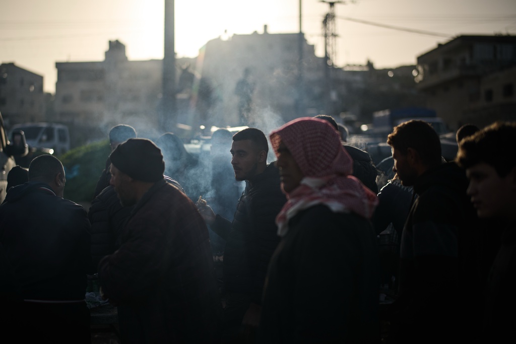 A Palestinian eats grilled chicken and lamb at a livestock market near Balata refugee camp on the outskirts of the West Bank city of Nablus, Thursday, Feb. 12, 2026. (AP Photo/Leo Correa)