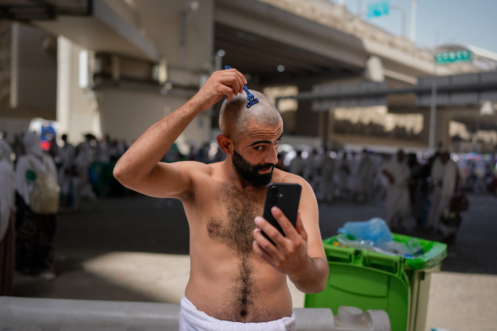 A Muslim pilgrim shaves his head, a ritual known as "halq" marking the completion of Hajj after the symbolic stoning of the devil, in Mina near the holy city of Mecca, Saudi Arabia, Wednesday, May 27, 2026. (AP Photo/Altaf Qadri)
