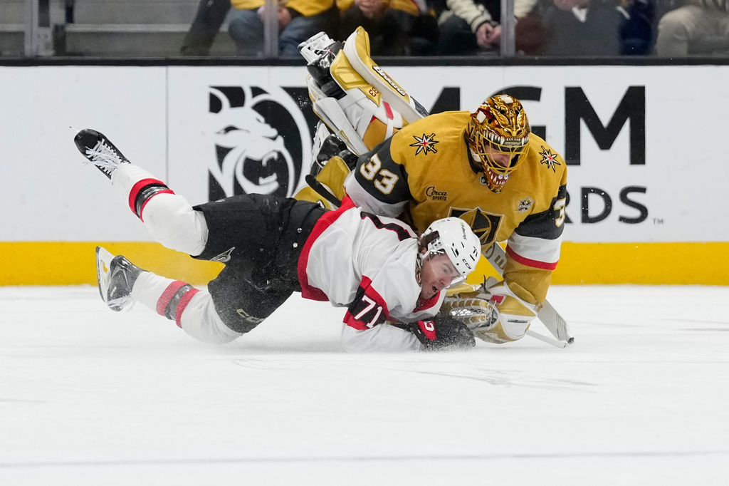 Vegas Golden Knights goaltender Adin Hill (33) drives into Ottawa Senators center Ridly Greig (71) during the second period of an NHL hockey game Tuesday, Oct. 27, 2026, in Las Vegas. (AP Photo/John Locher)