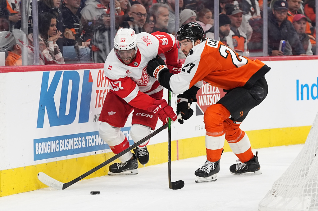Philadelphia Flyers' Noah Cates, right, and Detroit Red Wings' David Perron, left, battle for the puck during the first period of an NHL hockey game, Thursday, April 2, 2026, in Philadelphia. (AP Photo/Matt Rourke)