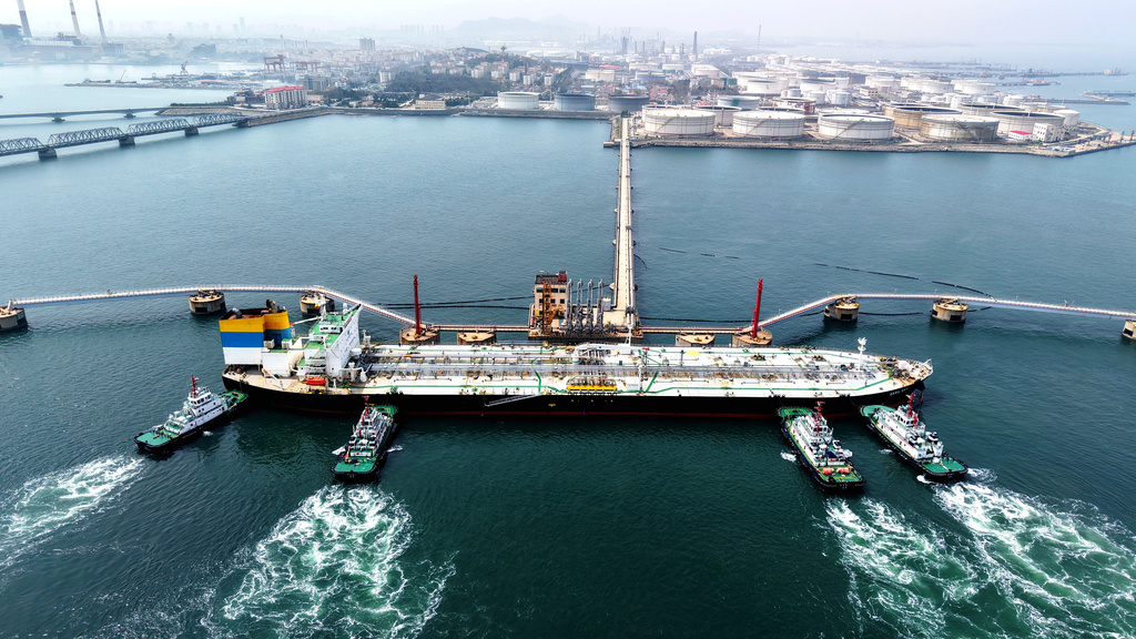 Tugboats push a crude oil tanker into position at a pier handling oil imports in Qingdao in eastern China's Shandong province, Saturday, April 11, 2026. (Chinatopix Via AP) CHINA OUT