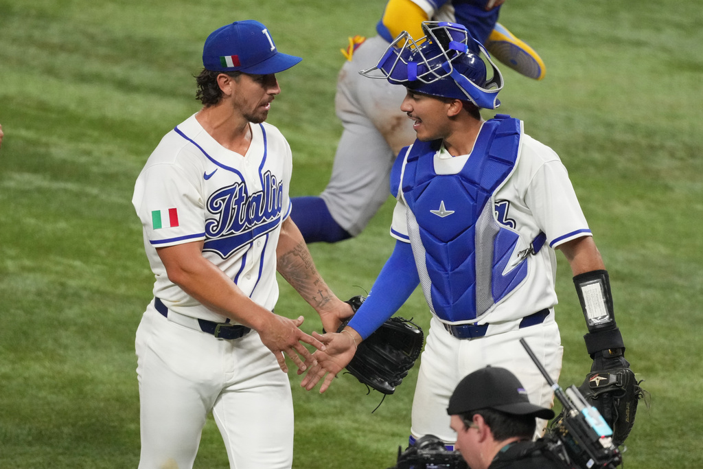 Italy pitcher Michael Lorenzen and catcher JJ D'Orazio shake hands during the fifth inning of a World Baseball Classic semifinal game against Venezuela, Monday, March 16, 2026, in Miami. (AP Photo/Lynne Sladky)
