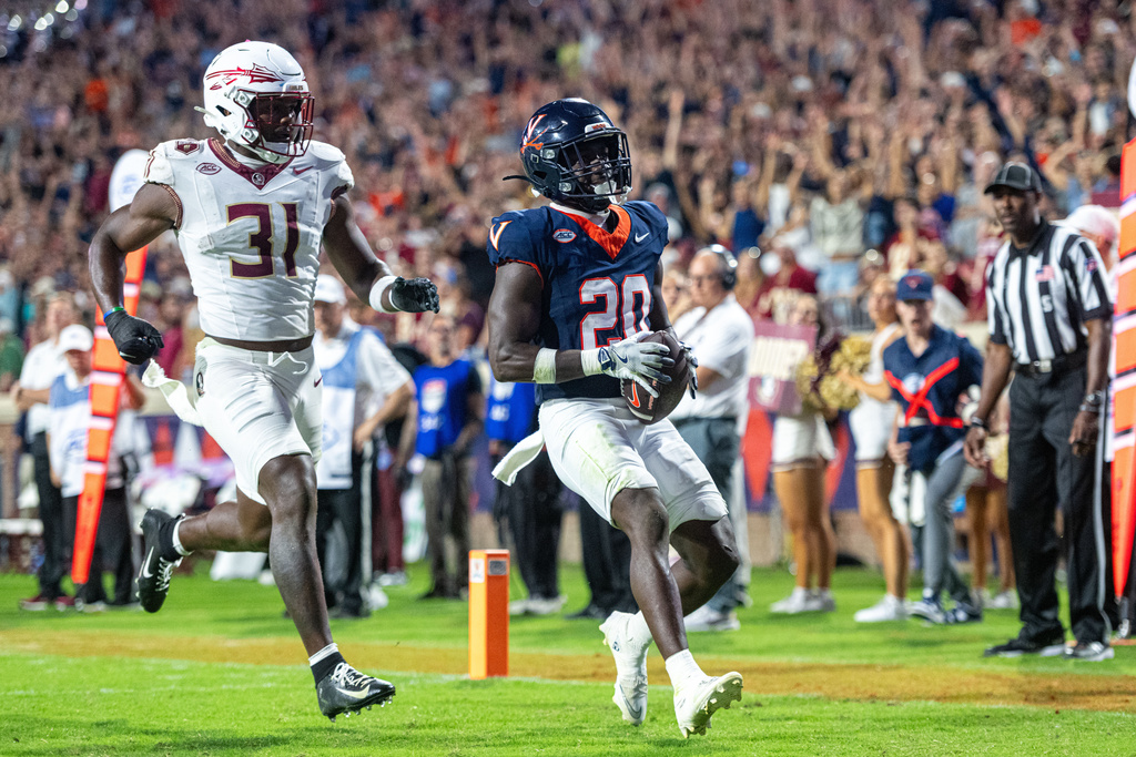 Virginia running back Xavier Brown (20) receives the ball for a touchdown during the second half of an NCAA college football game, Friday, Sept. 26 2025, in Charlottesville, Va. (AP Photo/Robert Simmons)