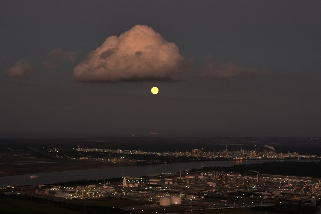In this aerial photo, a supermoon rises above the Dow Chemical Plant and the Shell Norco Oil Refinery along the Mississippi River in St. John the Baptist Parish, La., Wednesday, Nov. 5, 2025. (AP Photo/Gerald Herbert)