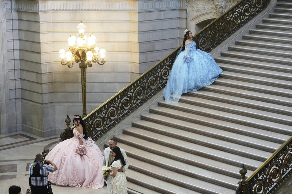 Abbie Gonzalez, top, poses in her quinceañera gown for her professional portrait session at City Hall in San Francisco, Monday, Aug. 25, 2025. (AP Photo/Jeff Chiu)