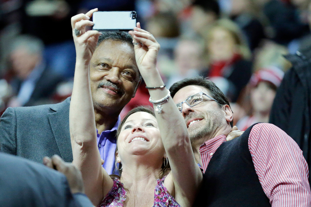 FILE - The Rev. Jesse Jackson, left, pose for photos with his fans before an NBA basketball game between the Houston Rockets and the Chicago Bulls in Chicago on Thursday, March 13, 2014. (AP Photo/Nam Y. Huh, File)