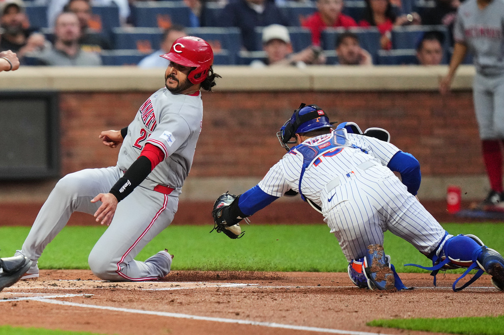 New York Mets catcher Luis Torrens, right, tags out Cincinnati Reds' Eugenio Suárez at home plate during the first inning of a baseball game Tuesday, May 26, 2026, in New York. (AP Photo/Frank Franklin II)