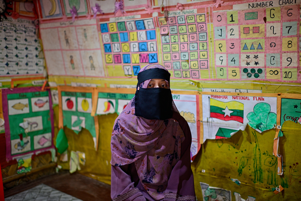 Rohingya refugee school teacher Noor Zia speaks to The Associated Press as she sits inside a classroom next to a drawing of the Myanmar flag inside the Rohingya refugee camp in Cox's Bazar, Bangladesh, Saturday, Nov. 22, 2025. (AP Photo/Mahmud Hossain Opu)