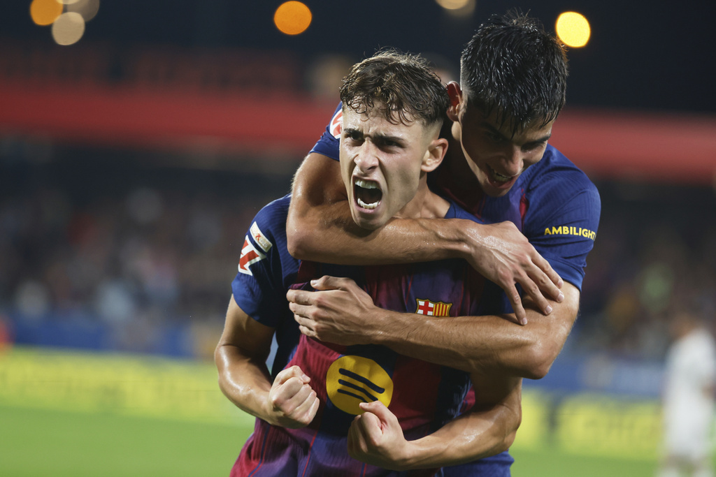 Barcelona's Fermin Lopez celebrates scoring his side's 3rd goal with teammate Gerard Martin during a Spanish La Liga soccer match between FC Barcelona and Valencia at the Johan Cruyff stadium in Barcelona, Spain, Sunday, Sept. 14, 2025. (AP Photo/Joan Monfort)