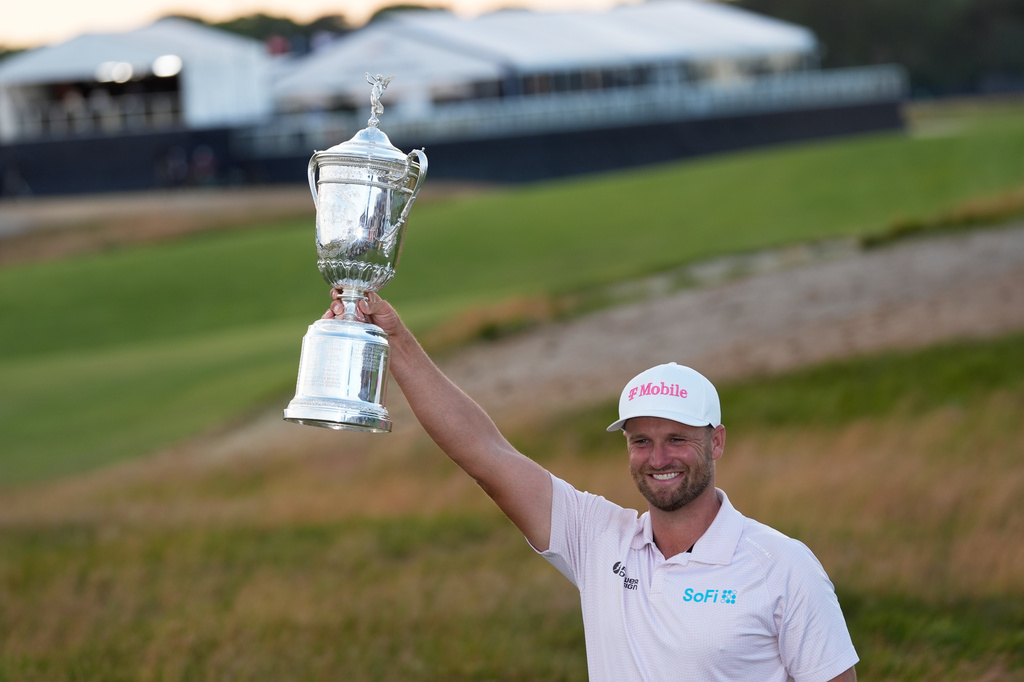 Wyndham Clark alza el trofeo después de ganar el Abierto de Estados Unidos de Golf, en el Club de Golf Shinnecock Hills, en Southampton, Nueva York, el domingo 21 de junio de 2026. (AP Foto/David J. Phillip)