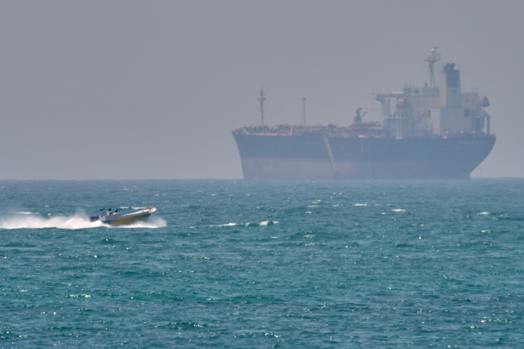 FILE - A boat sails past a tanker anchored on the Strait of Hormuz off the coast Qeshm island, Iran, April 18, 2026. (AP Photo/Asghar Besharati, File)