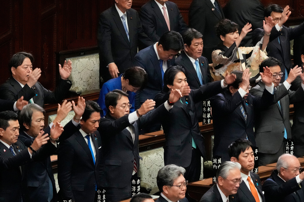 Japanese Prime Minister Sanae Takaichi, center in blue jacket, bows and other lawmakers cheer after dissolving the lower house, during an extraordinary Diet session at the lower house of parliament Friday, Jan. 23, 2026, in Tokyo. (AP Photo/Eugene Hoshiko)