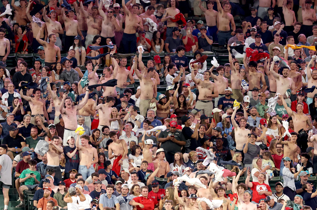 Fans wave their shirts in the outfield bleachers during the eighth inning of the second baseball game of a doubleheader between the Boston Red Sox and Tampa Bay Rays, Friday, July 17, 2026, in Boston. (AP Photo/Mark Stockwell)