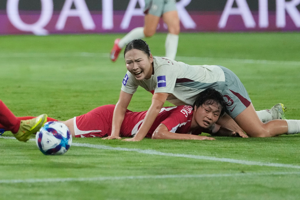 North Korea's Ri Hye Gyong, bottom, and China's Wurigumula compete for the ball during the Women's Asian Cup soccer match between China and North Korea in Sydney, Monday, March 9, 2026. (AP Photo/Rick Rycroft)