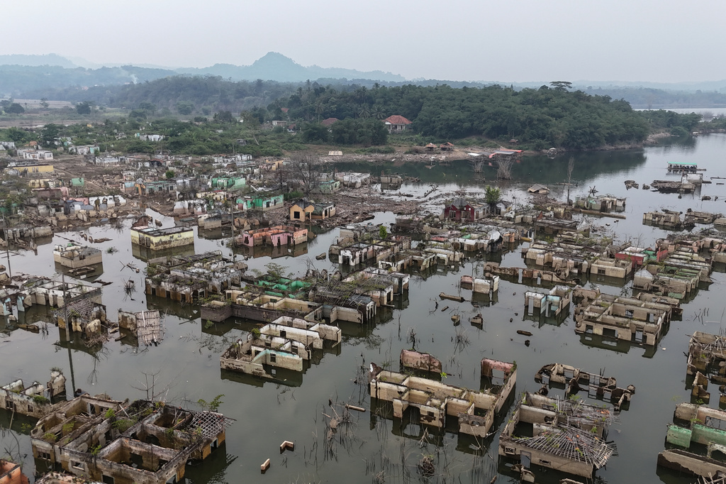 Long-submerged houses are exposed after prolonged drought lowers the water level of Karian Dam, in Lebak, Banten Province, Indonesia, Friday, July 31, 2026. (AP Photo/Tatan Syuflana)