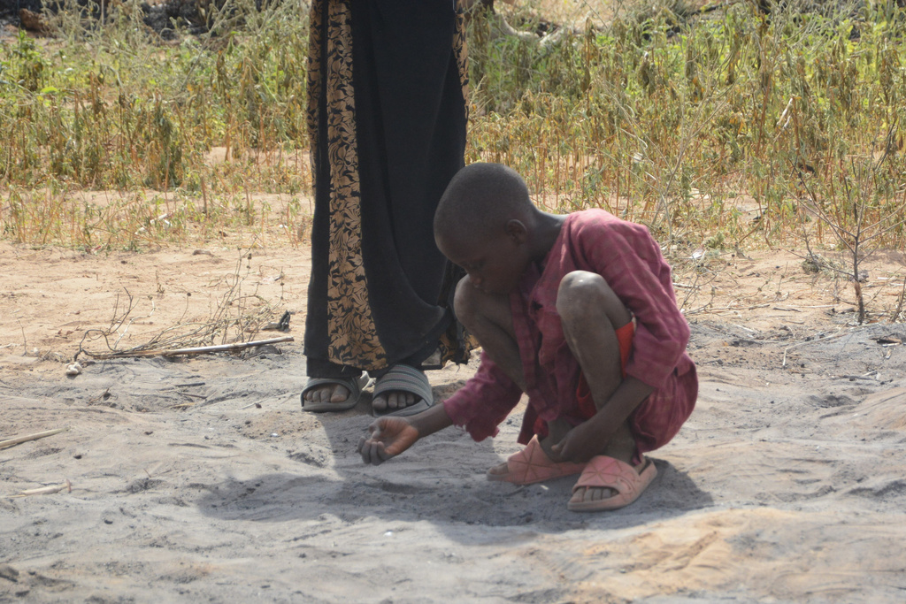 A boy picks debris at the site of a U.S. airstrike in Northwest, Jabo, Nigeria, Friday, Dec. 26, 2025. (AP Photo/ Tunde Omolehin)