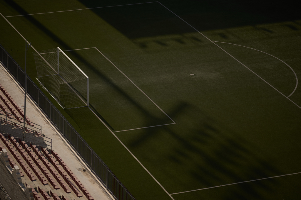 The shadow of a light pole stretches across the artificial turf at Faisal al-Husseini Stadium in the West Bank town of Al-Ram, Monday, May 11, 2026. (AP Photo/Leo Correa)