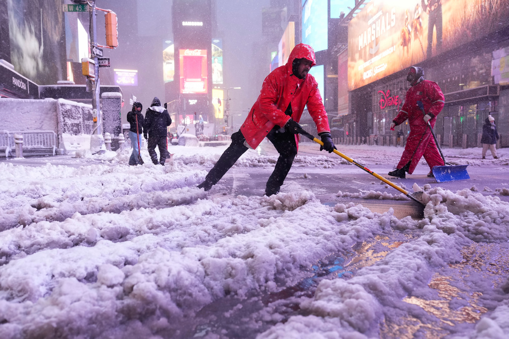 A worker with the Times Square Alliance sanitation crew shovels snow in Times Square, Monday, Feb. 23, 2026, in New York. (AP Photo/Seth Wenig)