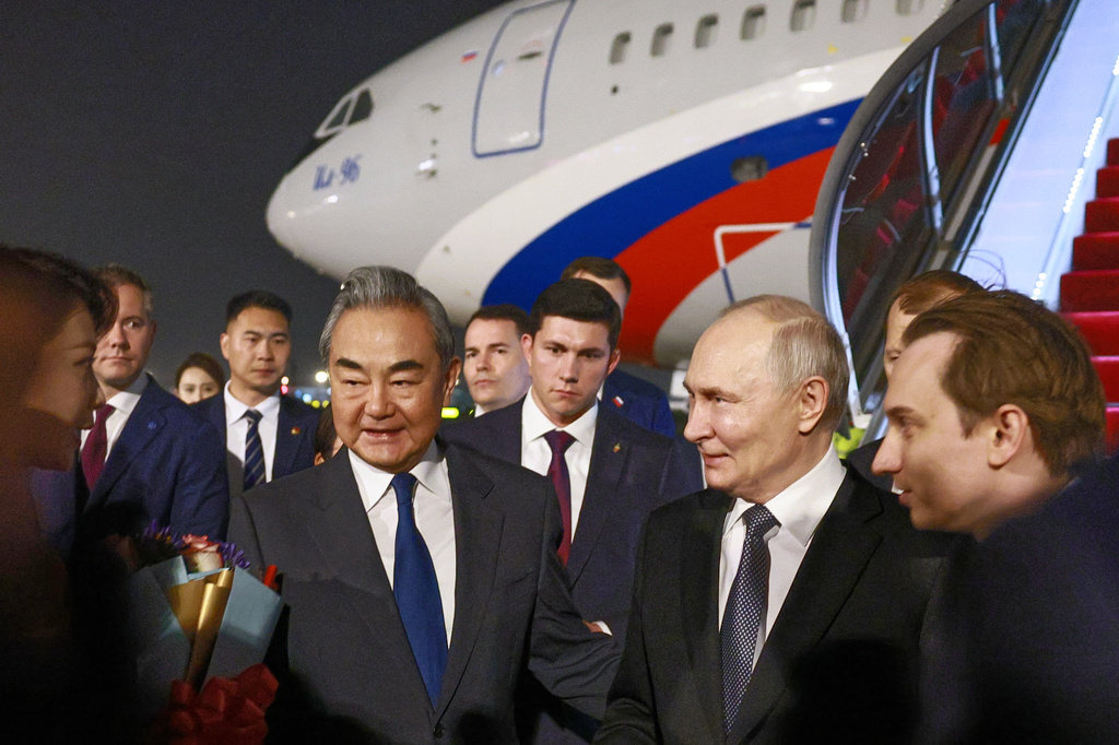 Russian President Vladimir Putin, center right, is greeted by China's Foreign Minister Wang Yi, center left, as he arrives in Beijing, Tuesday, May 19, 2026. (Vladimir Smirnov, Sputnik, Kremlin Pool Photo via AP)