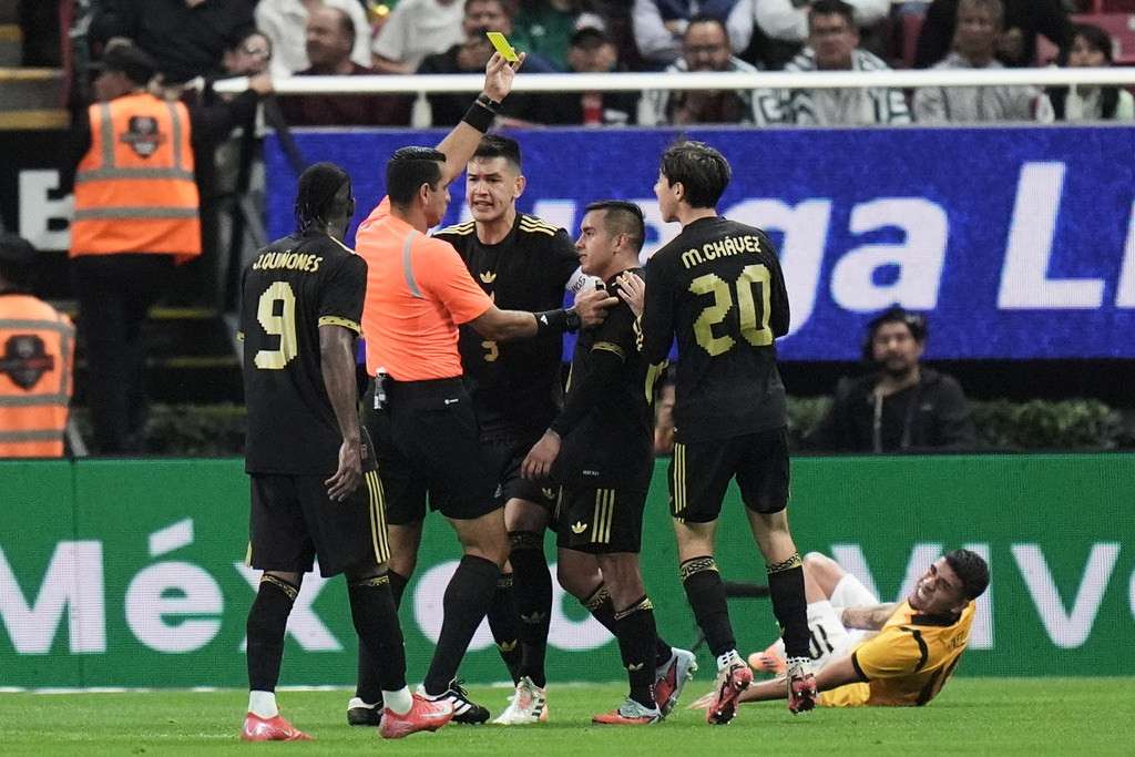Referee Juan Calderon shows a yellow card to Mexico's Érick Sánchez during a friendly soccer match against Ecuador at Akron stadium in Guadalajara, Mexico, Tuesday, Oct. 14, 2025. (AP Photo/Eduardo Verdugo)