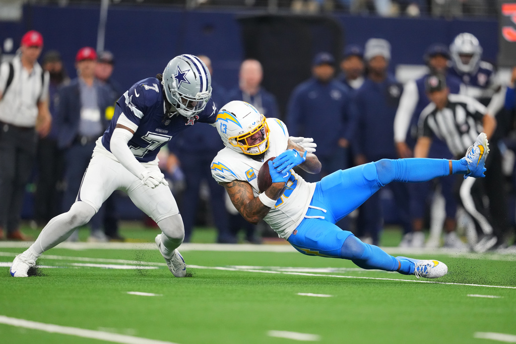 Los Angeles Chargers wide receiver Keenan Allen (13) makes a catch in front of Dallas Cowboys cornerback Trevon Diggs (7) during the first half of an NFL football game Sunday, Dec. 21, 2025, in Arlington, Texas. (AP Photo/Julio Cortez)