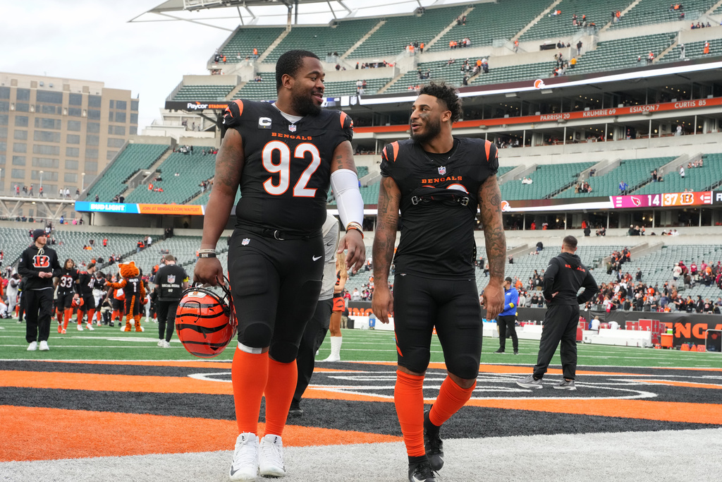Cincinnati Bengals defensive tackle B.J. Hill (92) leaves the field with safety Geno Stone, right, after an NFL football game against the Arizona Cardinals, Sunday, Dec. 28, 2025, in Cincinnati. (AP Photo/Jeff Dean)