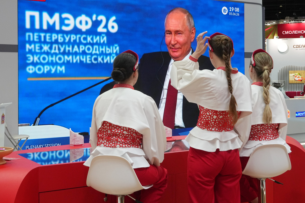 Participants watch a broadcast of Russian President Vladimir Putin's speech on a TV screen during a plenary session of the St. Petersburg International Economic Forum in St. Petersburg, Russia, Friday, June 5, 2026. (AP Photo/Dmitri Lovetsky)