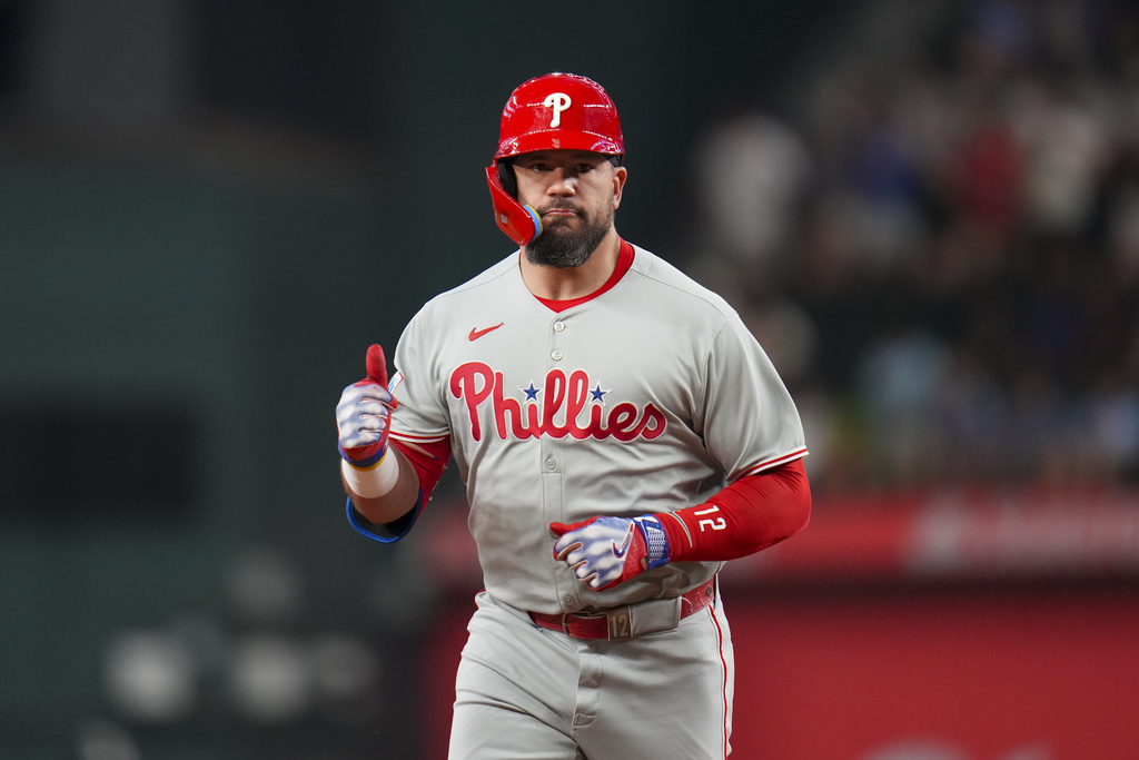 Philadelphia Phillies designated hitter Kyle Schwarber gestures while running the bases after hitting a solo home run off Texas Rangers pitcher Merrill Kelly during the first inning of a baseball game Friday, Aug. 8, 2025, in Arlington, Texas. (AP Photo/Julio Cortez)